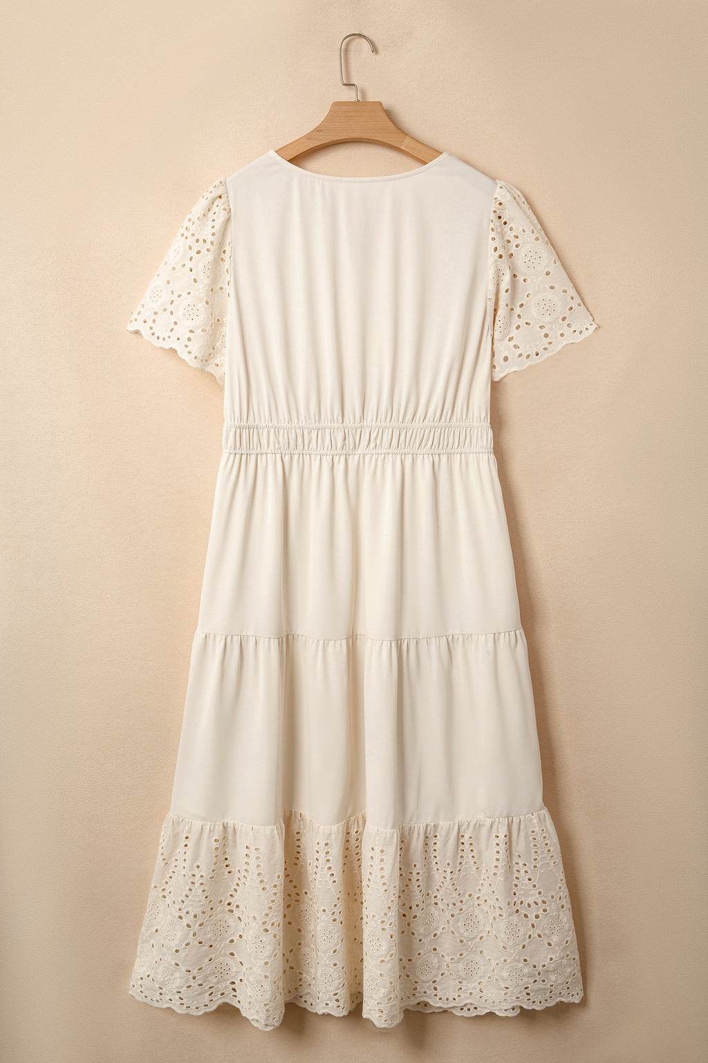 Vestido comprido plus size com decote em V e aplicações de ilhós bordados.