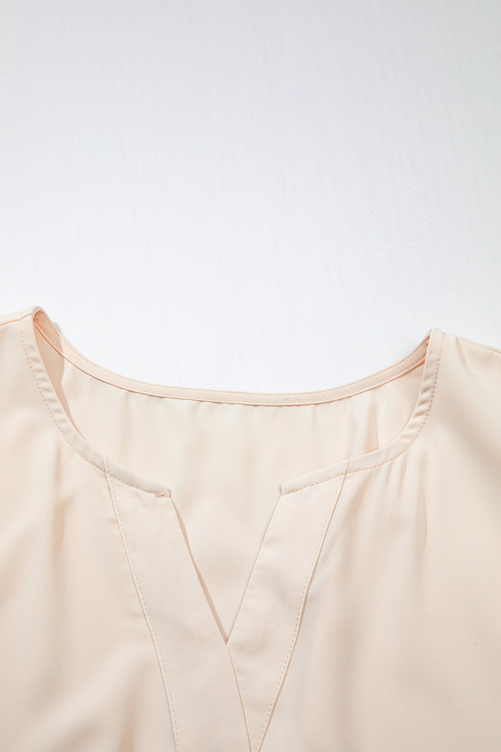 Vestido comprido plus size com decote em V e aplicações de ilhós bordados.
