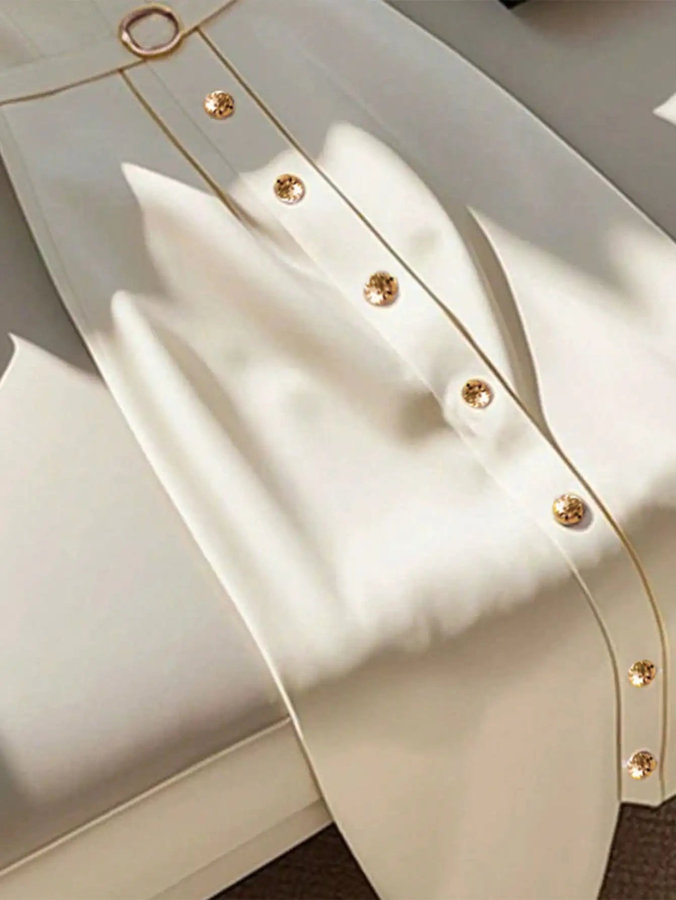 Blusa de senhora elegante, simples, com decote redondo, abotoamento simples e manga curta. Cinto.