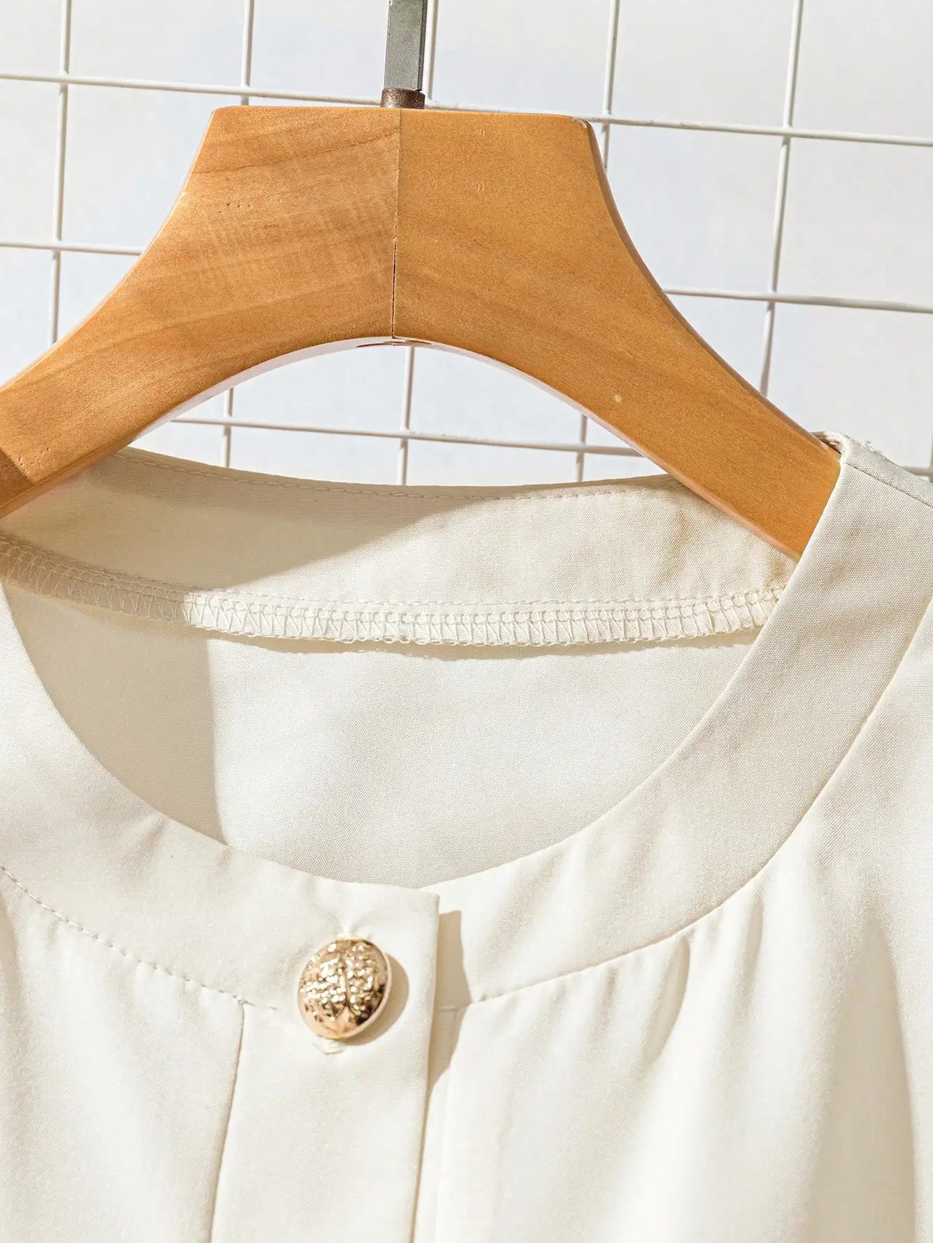Blusa de senhora elegante, simples, com decote redondo, abotoamento simples e manga curta. Cinto.