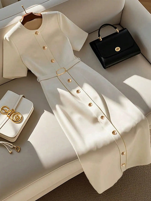 Blusa de senhora elegante, simples, com decote redondo, abotoamento simples e manga curta. Cinto.