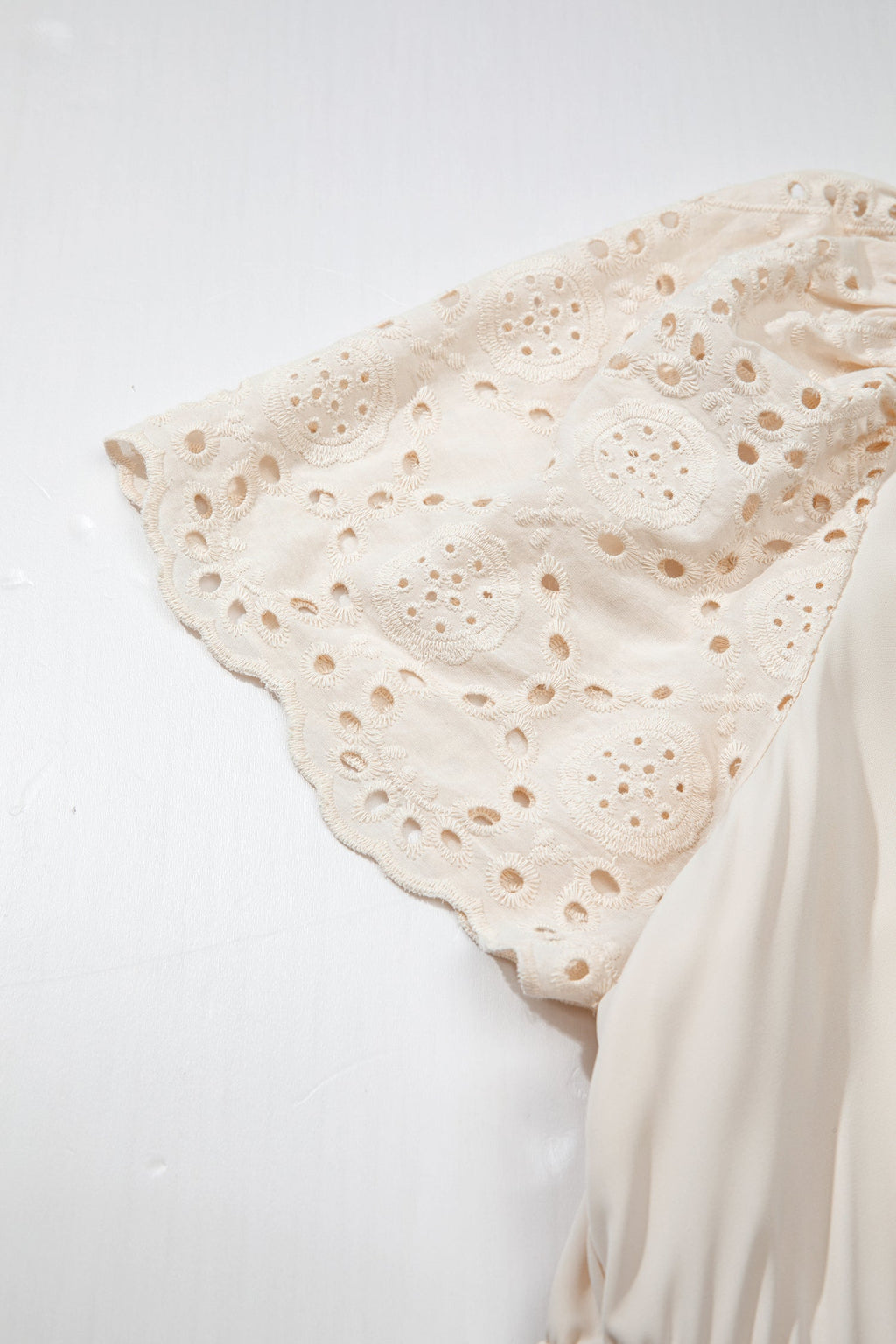 Vestido comprido plus size com decote em V e aplicações de ilhós bordados.